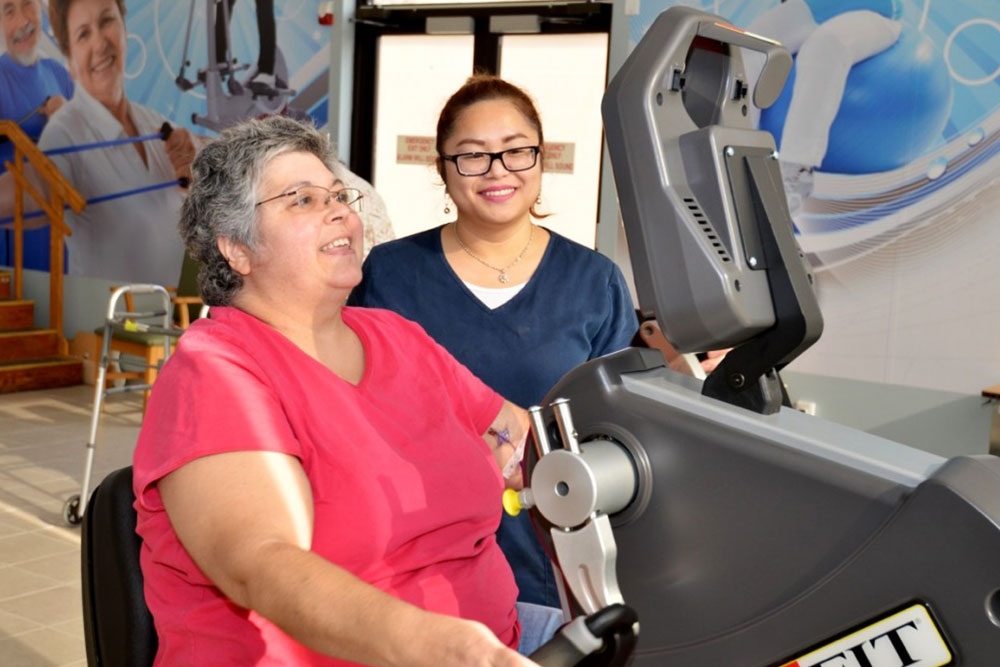 Senior patient working with therapist in exercise room.